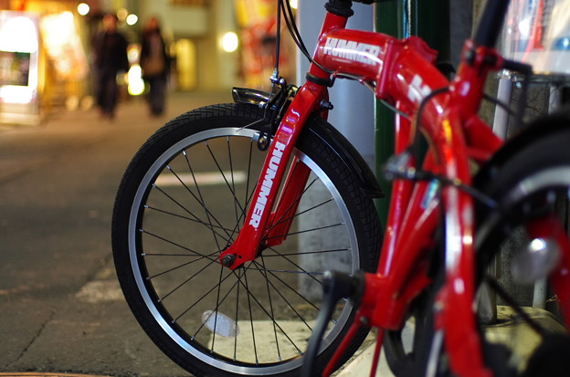 写真: 赤い自転車と街の灯