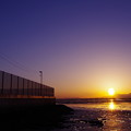 写真: フェンスと夕陽
