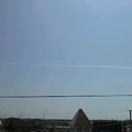 写真: 東の空に長い一直線の飛行機...