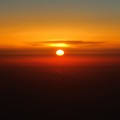 写真: 飛行機から眺める日の出