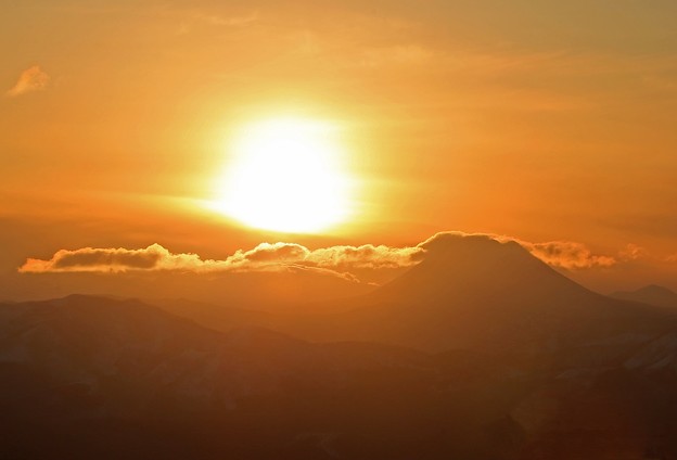 写真: 阿寒岳に沈む夕陽