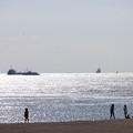 写真: 大きな船と海岸で遊ぶ子供達と