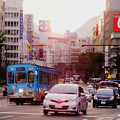 写真: 種々雑多な乗り物が走る熊本の街。