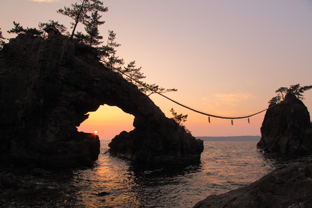 写真: 機具岩（はたごいわ）　岩穴に沈む夕陽(2)