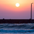 写真: 春の海と夕陽