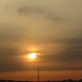 地平線近く帯状の雲に朝陽が見える